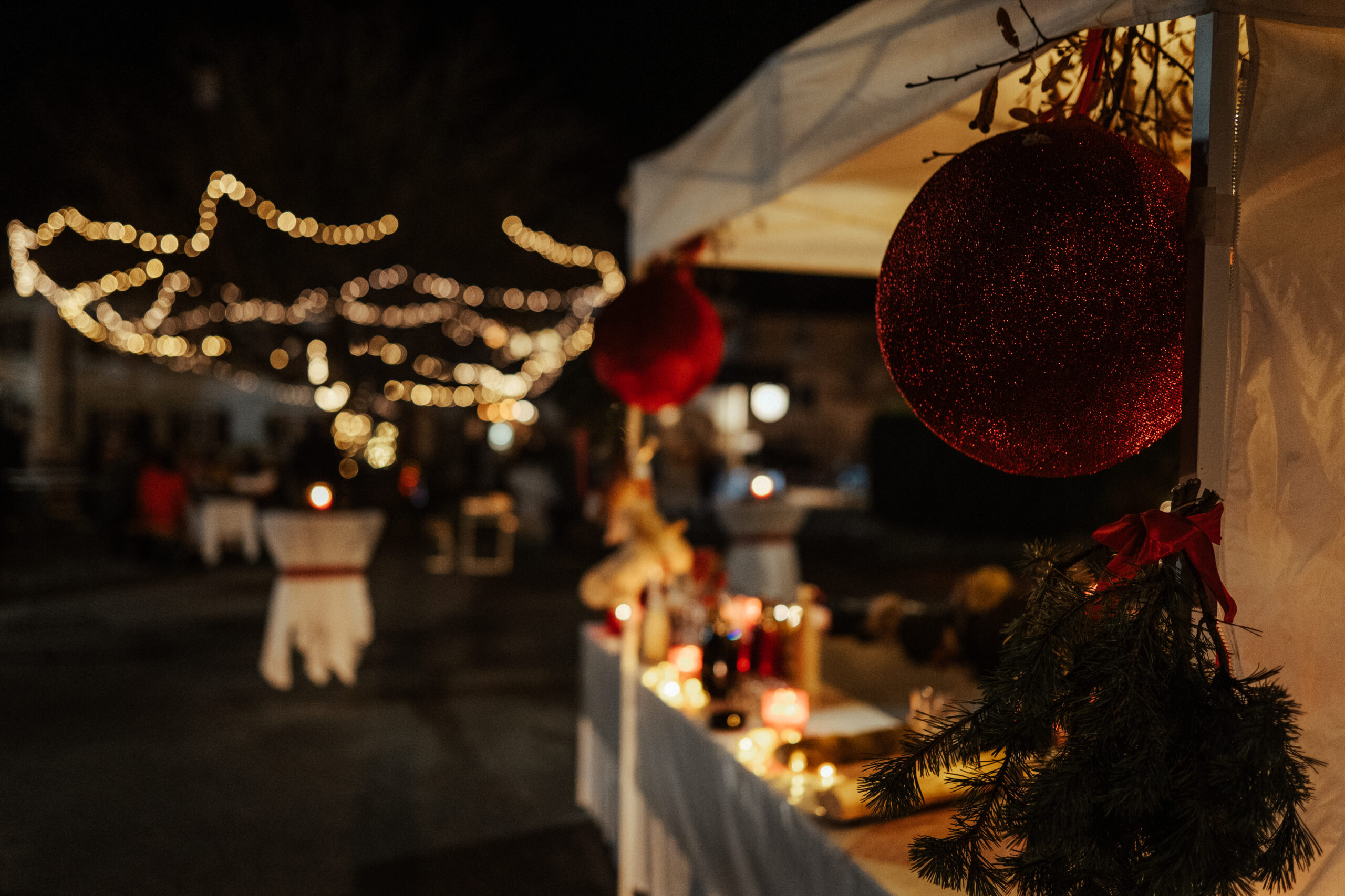 Adventmarkt mit Weihnachtskugel im Vordergrund